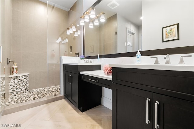 bathroom with visible vents, vanity, a shower stall, and tile patterned flooring