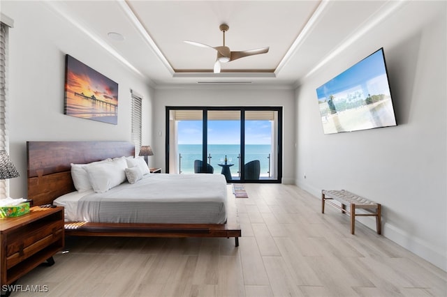 bedroom with baseboards, ornamental molding, light wood-style floors, a raised ceiling, and access to outside