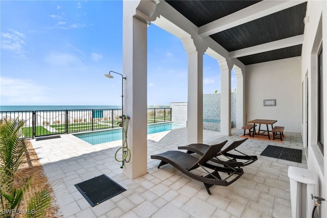 view of patio featuring a fenced in pool and a water view