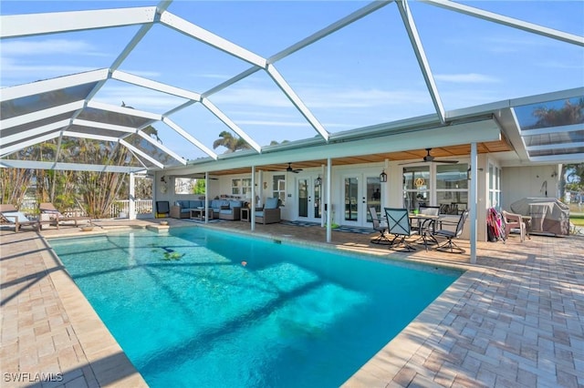 view of swimming pool featuring french doors, area for grilling, a lanai, ceiling fan, and a patio area