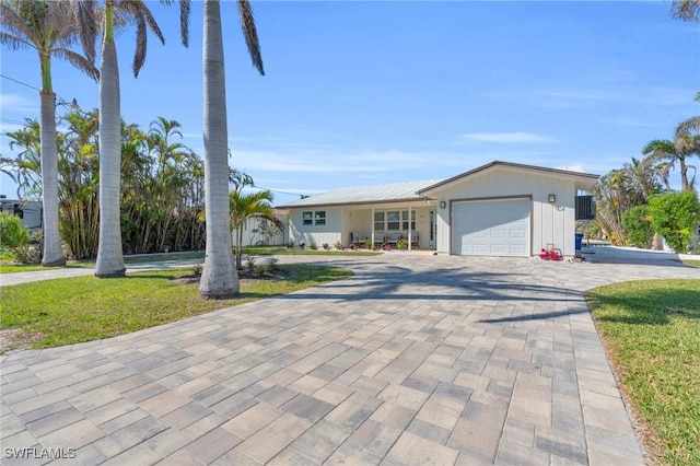 single story home with a garage and a front lawn