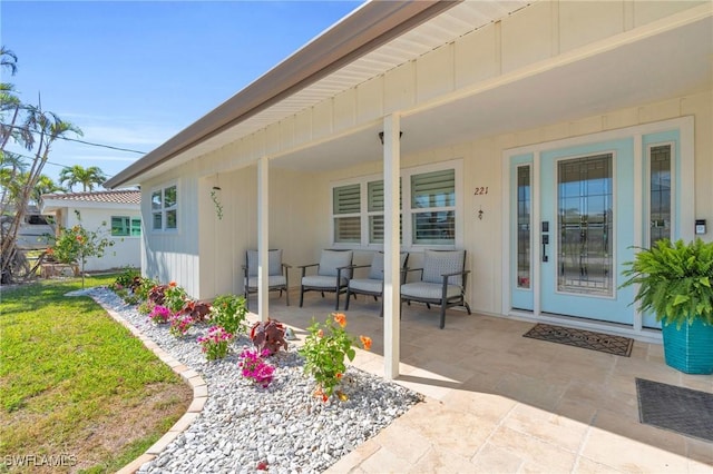 doorway to property with a lawn and a patio