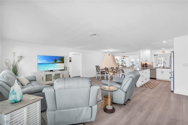 living area featuring light wood finished floors and visible vents