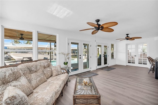 living room with french doors, ceiling fan, and wood-type flooring