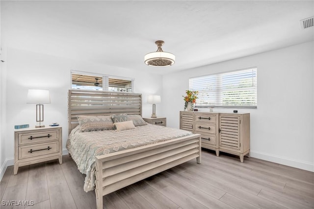 bedroom featuring visible vents, light wood-style flooring, and baseboards