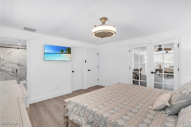 bedroom with connected bathroom, light hardwood / wood-style flooring, and french doors