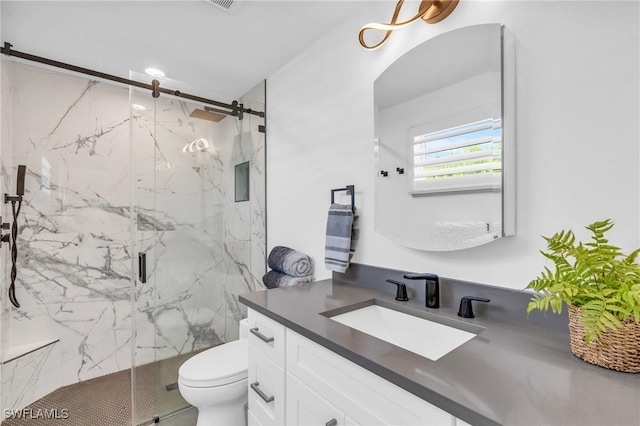 bathroom featuring vanity, an enclosed shower, and toilet