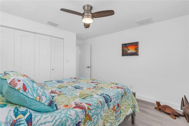 bedroom with hardwood / wood-style flooring, a closet, and ceiling fan