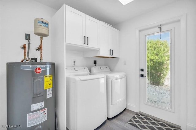 clothes washing area featuring cabinets, separate washer and dryer, electric water heater, and light wood-type flooring