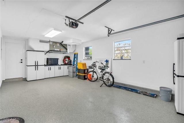 garage featuring white refrigerator and a garage door opener