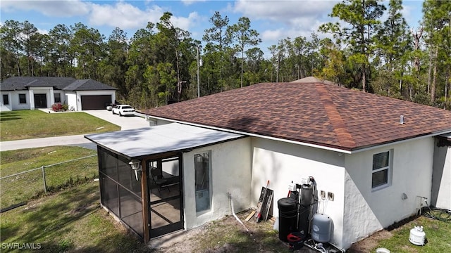 rear view of property featuring a sunroom and a lawn