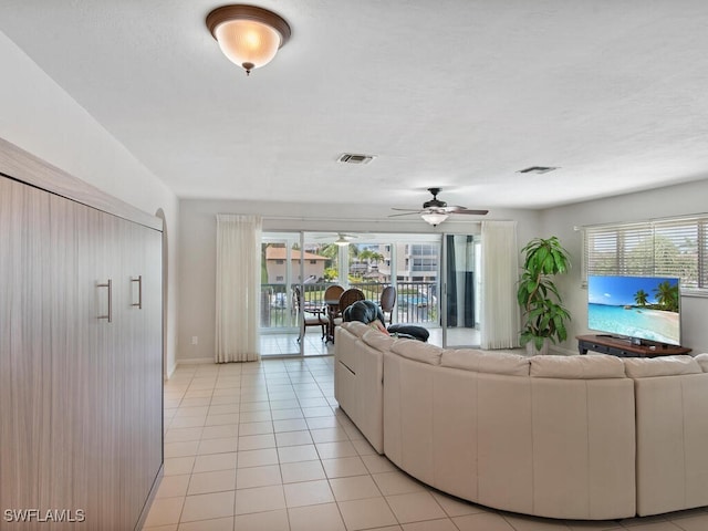 unfurnished living room with light tile patterned floors and ceiling fan