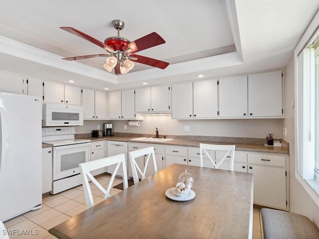 kitchen with light tile patterned flooring, sink, white cabinetry, a tray ceiling, and white appliances