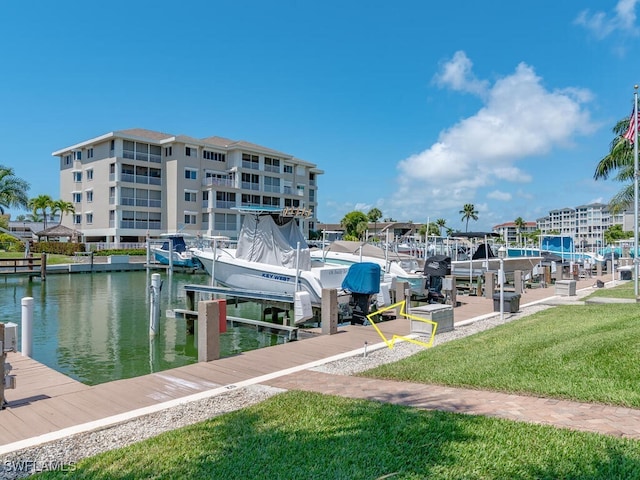 view of dock with a yard and a water view