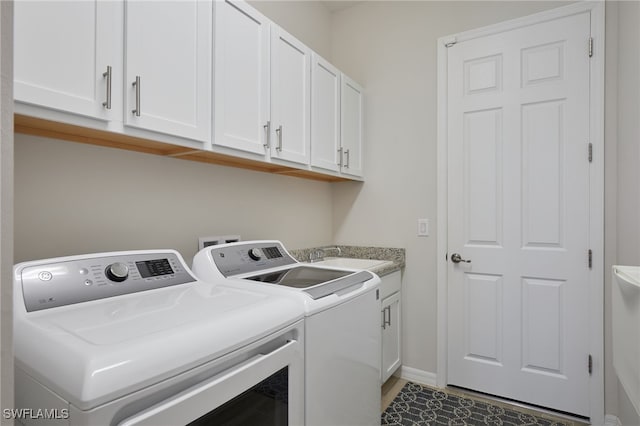 washroom featuring sink, cabinets, and washing machine and clothes dryer