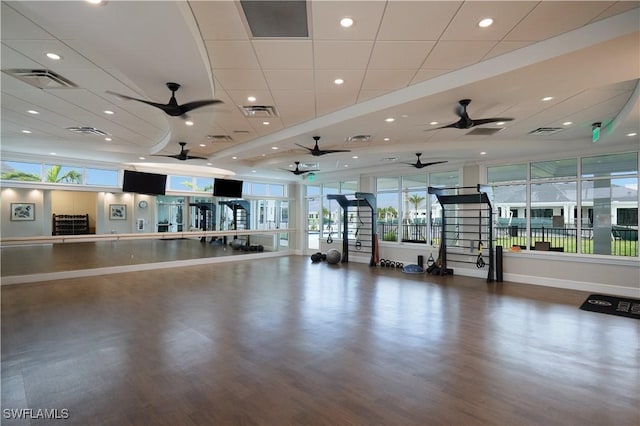 workout area with a paneled ceiling and hardwood / wood-style floors