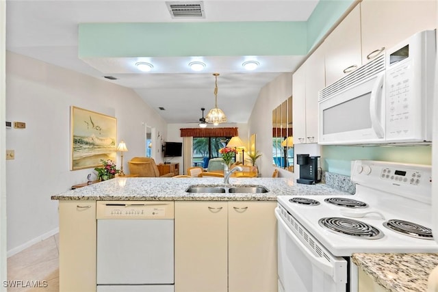 kitchen featuring cream cabinetry, sink, white appliances, and kitchen peninsula