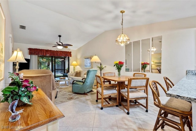 dining room with light tile patterned floors, ceiling fan with notable chandelier, and vaulted ceiling