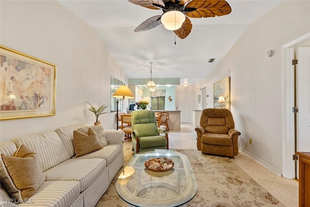 tiled living room with lofted ceiling and ceiling fan with notable chandelier