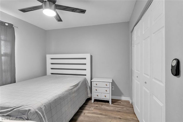 bedroom featuring ceiling fan, wood-type flooring, and a closet