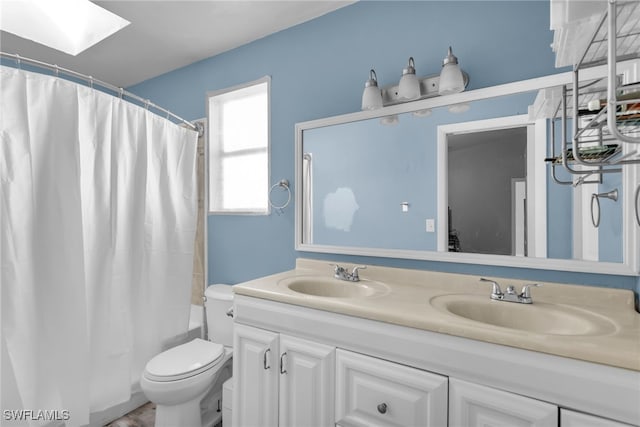 full bathroom featuring vanity, toilet, a skylight, and shower / tub combo