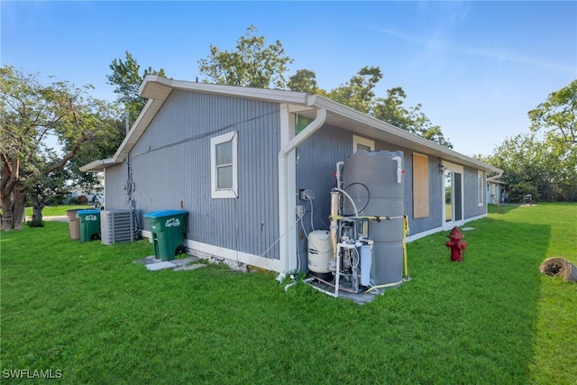 view of side of property with cooling unit and a lawn