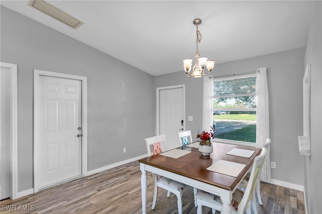 dining room featuring hardwood / wood-style floors and a chandelier