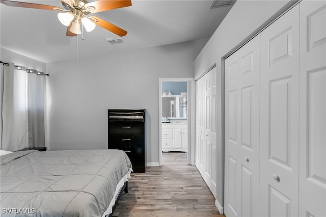 bedroom with ceiling fan, light hardwood / wood-style flooring, and multiple closets