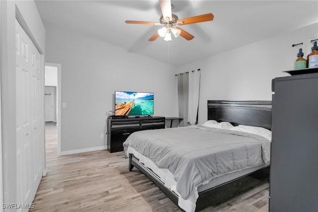 bedroom with vaulted ceiling, ceiling fan, and light wood-type flooring