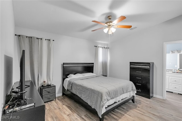 bedroom with ceiling fan, ensuite bathroom, and light hardwood / wood-style floors