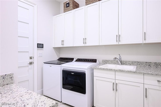 laundry room featuring cabinets, sink, and washer and dryer