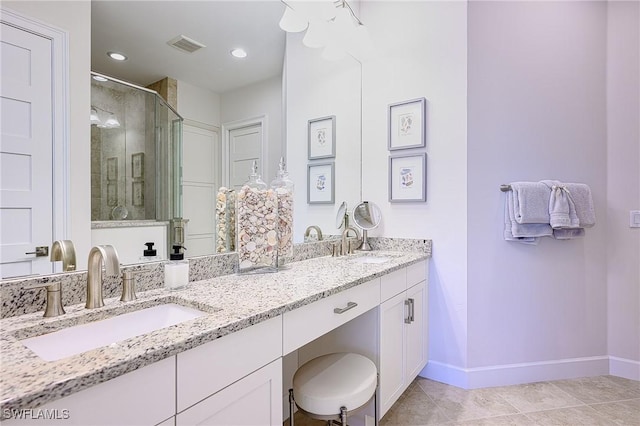 bathroom with tile patterned flooring, vanity, and walk in shower