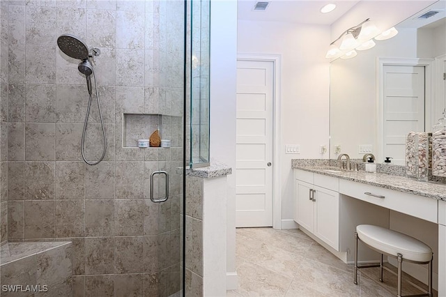 bathroom with vanity and a shower with door