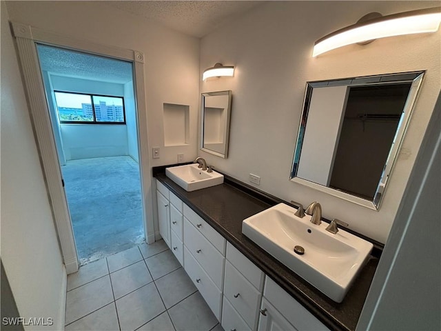 bathroom featuring tile patterned flooring, vanity, and a textured ceiling