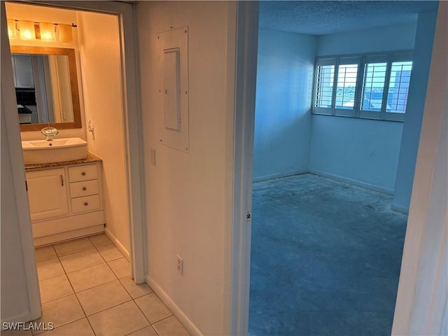 bathroom featuring tile patterned flooring, vanity, electric panel, and a textured ceiling