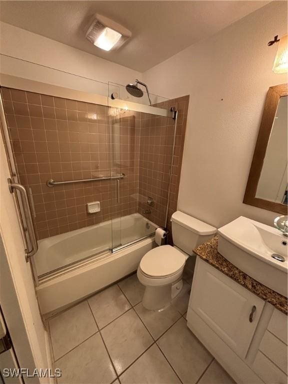 full bathroom featuring vanity, tile patterned flooring, combined bath / shower with glass door, and toilet