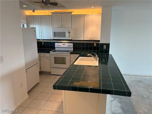 kitchen featuring sink, white appliances, tile counters, decorative backsplash, and kitchen peninsula