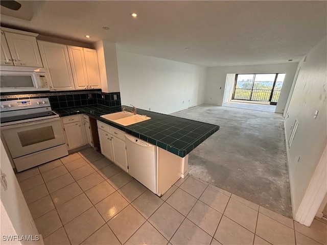 kitchen featuring sink, tasteful backsplash, tile countertops, kitchen peninsula, and white appliances