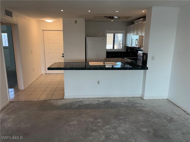 kitchen featuring sink, white cabinets, tile counters, kitchen peninsula, and stainless steel appliances