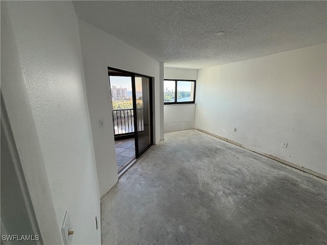 unfurnished room with concrete floors and a textured ceiling