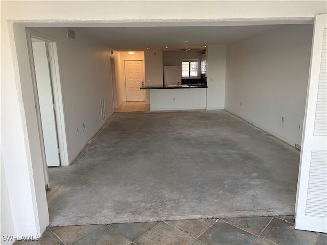 unfurnished living room with concrete floors