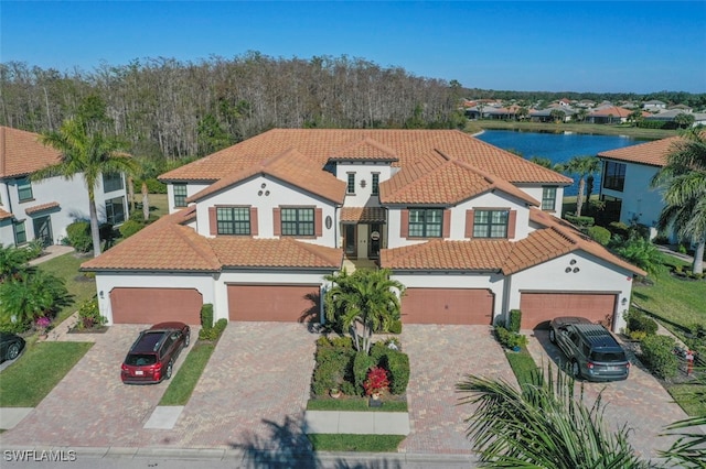 mediterranean / spanish-style house with a garage and a water view