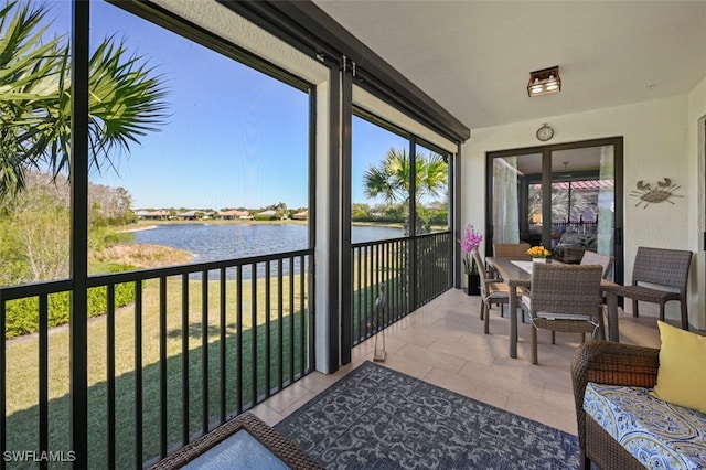 sunroom / solarium featuring a water view and a healthy amount of sunlight