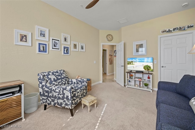 living area featuring light colored carpet and ceiling fan