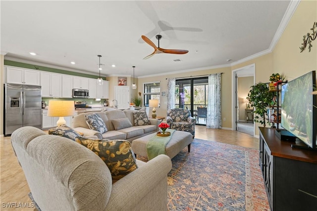 living room featuring sink, crown molding, and ceiling fan