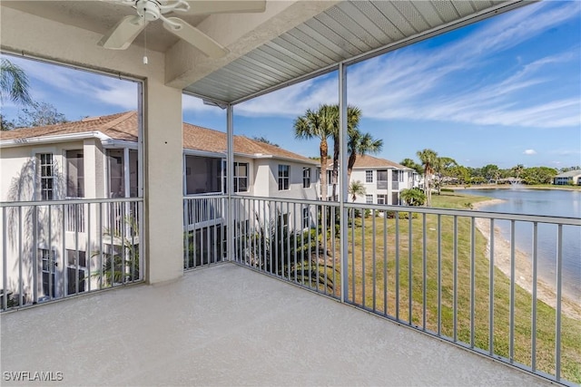 balcony featuring a water view and ceiling fan