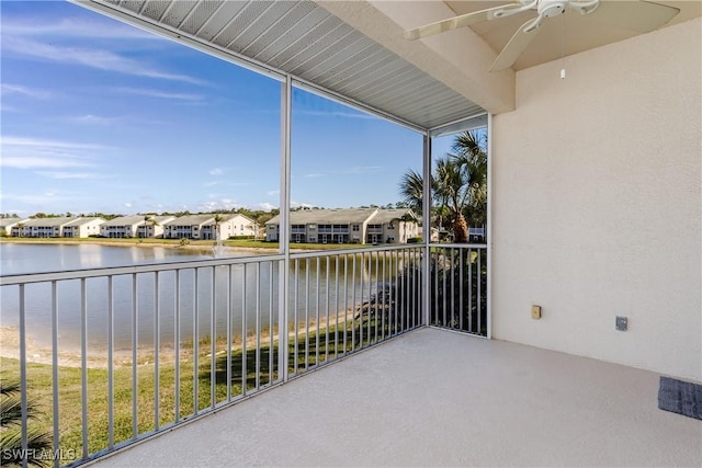 balcony with ceiling fan and a water view