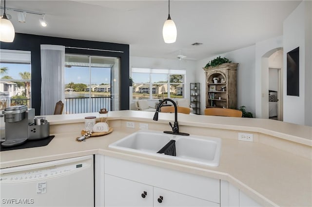 kitchen with sink, white cabinetry, decorative light fixtures, white dishwasher, and ceiling fan