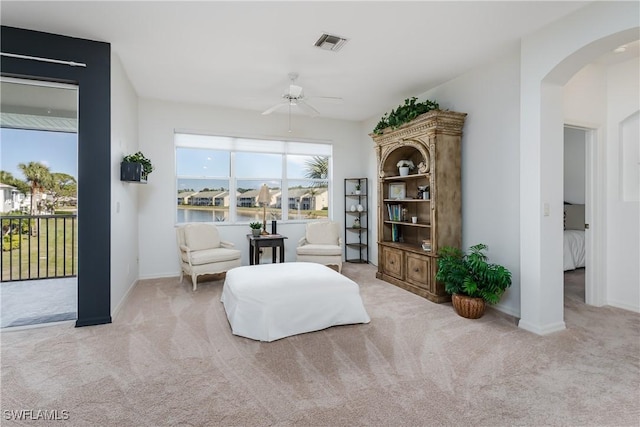 living area featuring light colored carpet and ceiling fan