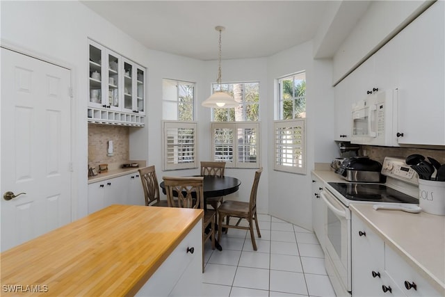 kitchen featuring pendant lighting, white appliances, white cabinetry, and backsplash